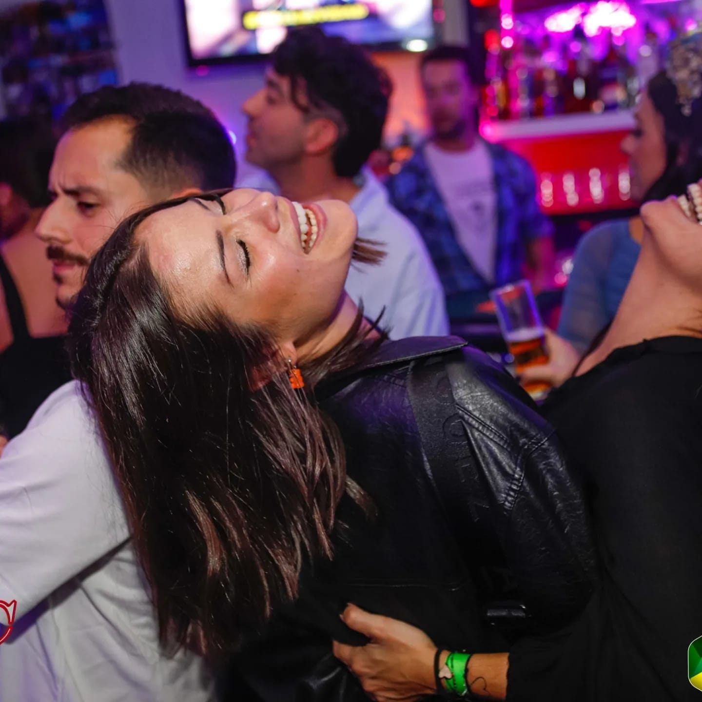Grupo de amigos bailando y riéndose junto a la barra durante una fiesta en TBC Huertas